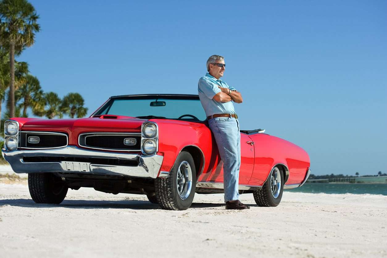 Snowbird Auto Transport Older Gentleman Leaning On Red Convertible
